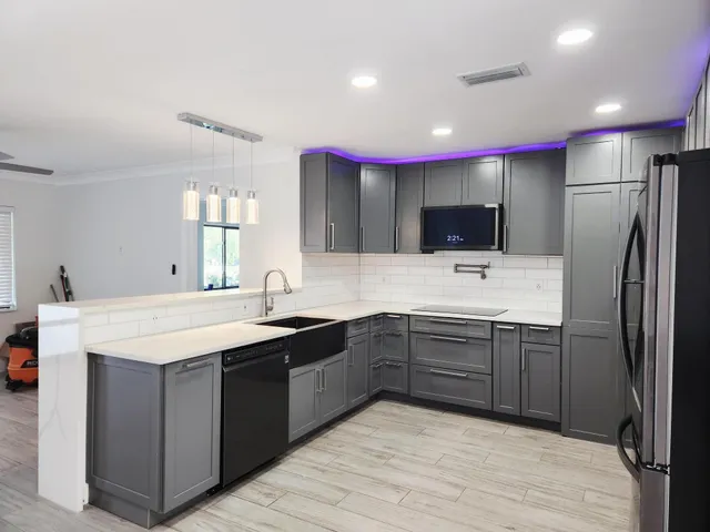 a kitchen with kitchen island cabinets a sink stainless steel appliances and a window
