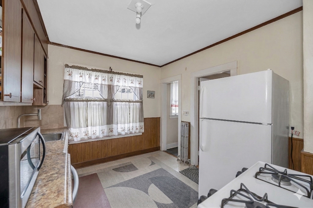 481 Lagrange Street Boston, MA 02132 - Photo 12 of 32 a room with a bed and a refrigerator