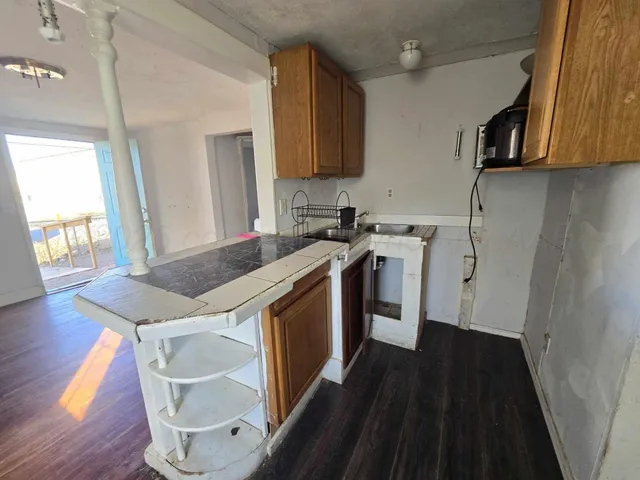 a kitchen with a sink a stove a microwave and wooden floor
