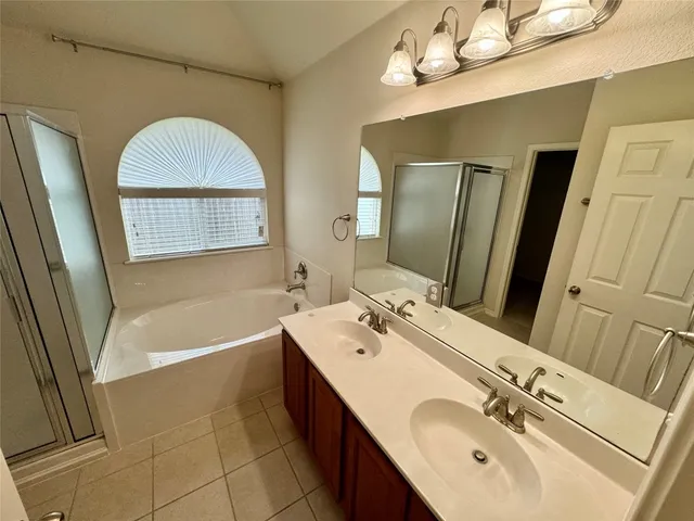 a bathroom with a tub a sink and a window