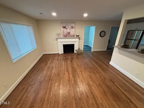 a view of a livingroom with wooden floor and a fireplace