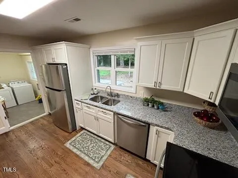 a kitchen with sink refrigerator and window