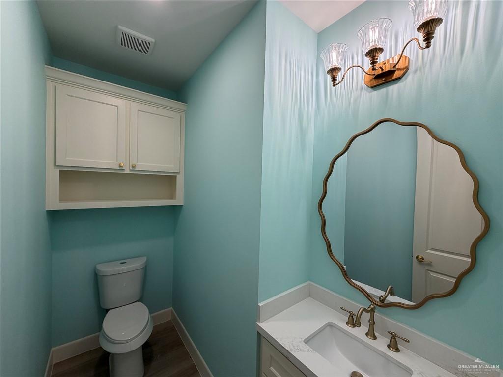 7817 North 40th Street McAllen, TX 78504 - Photo 13 of 22 a bathroom with a toilet a sink and mirror