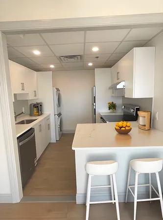 a kitchen with white cabinets and white appliances