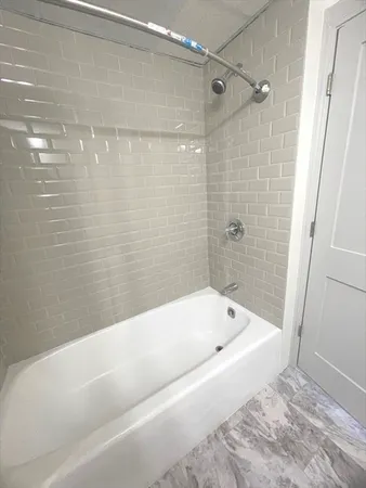 a bathroom with a bathtub and shower