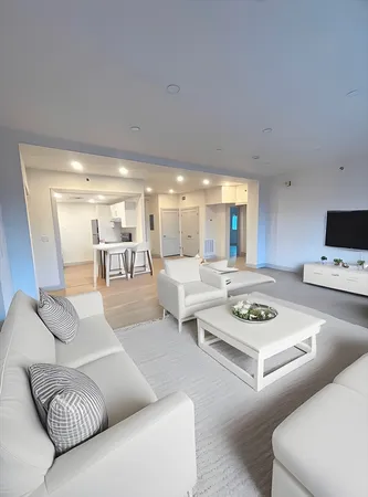 a living room with furniture and view of kitchen