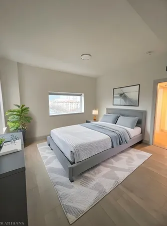 a bedroom with a bed and a potted plant