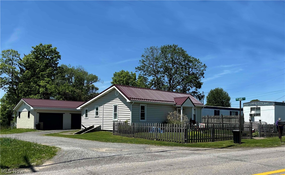 403 Lee Single-story home -featuring light-colored siding and a deep red metal roof