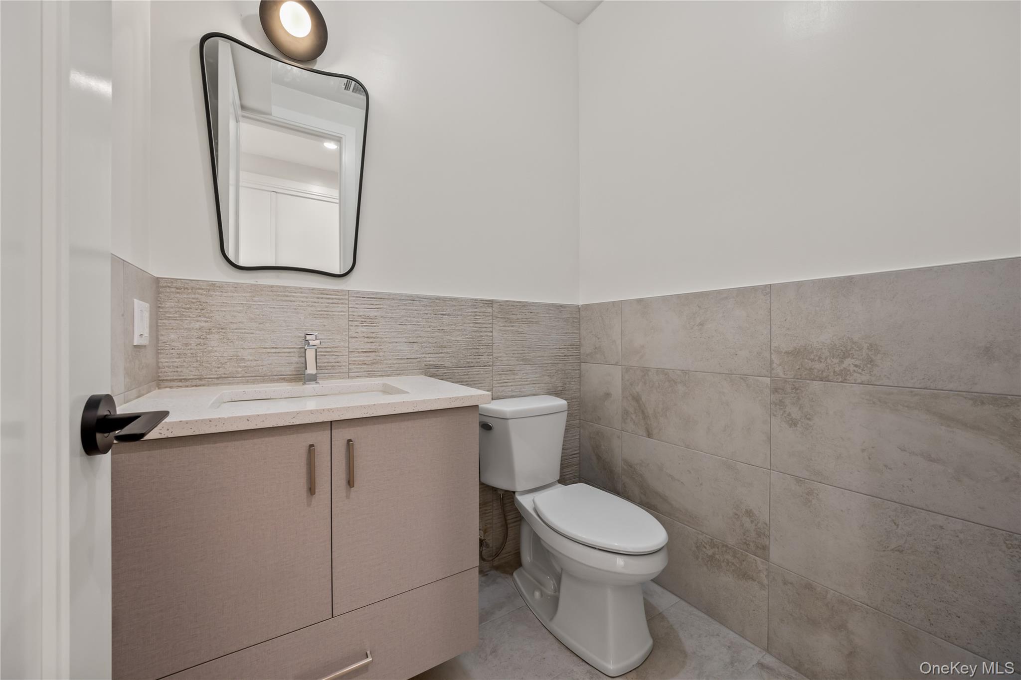 57 Dessau Circle Spring Valley, NY 10977 - Photo 25 of 48 Bathroom with vanity, tile walls, light tile patterned floors, and a wainscoted wall
