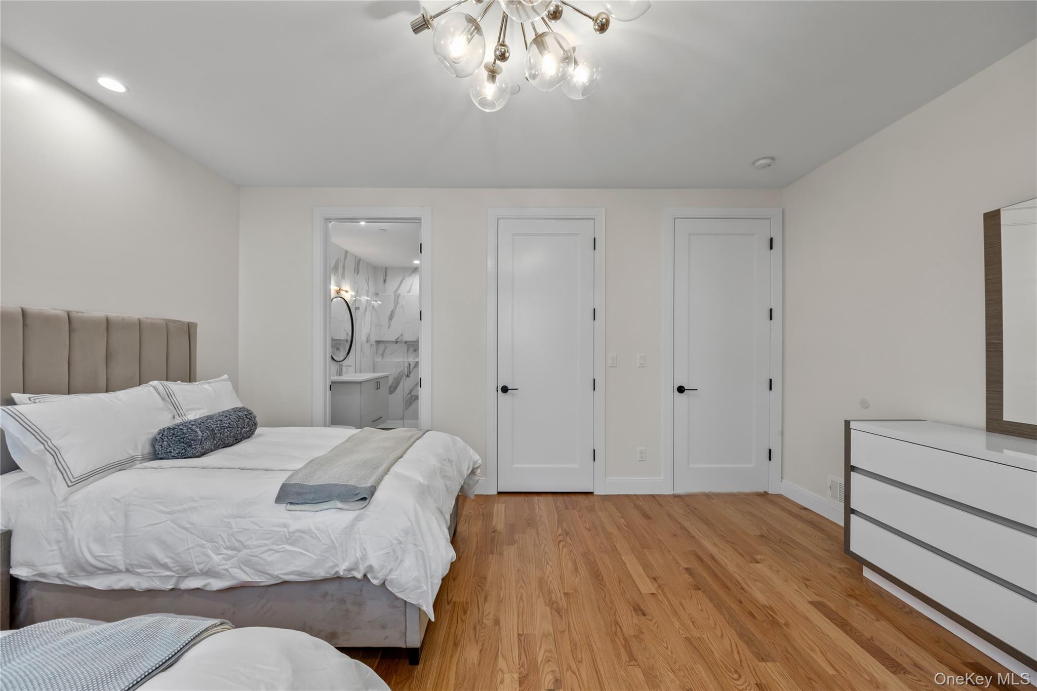 57 Dessau Circle Spring Valley, NY 10977 - Photo 28 of 48 Bedroom with light wood-style flooring, a chandelier, and ensuite bathroom