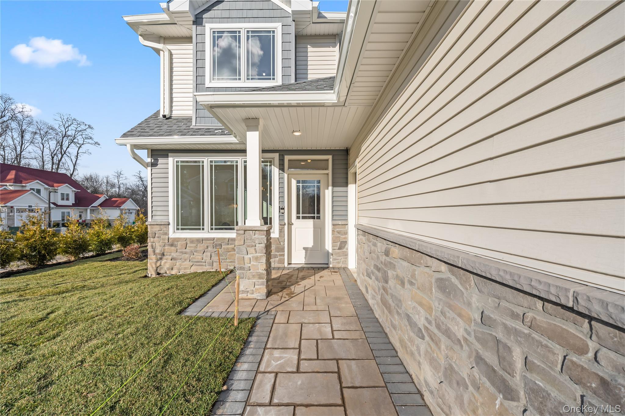57 Dessau Circle Spring Valley, NY 10977 - Photo 48 of 48 Property entrance featuring a shingled roof, a lawn, and stone siding