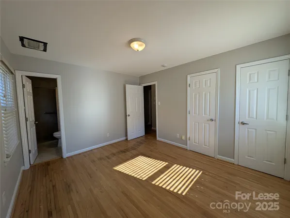 a view of empty room with wooden floor