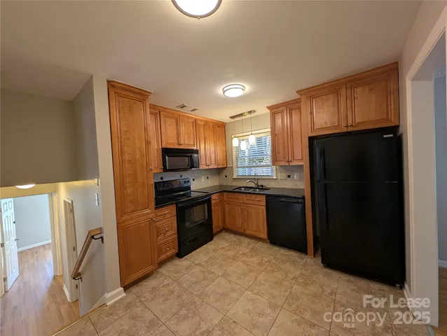 a kitchen with a refrigerator a stove top oven a sink and dishwasher