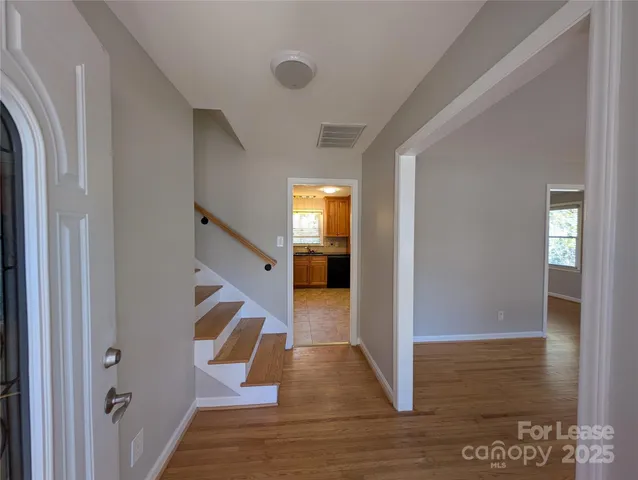 a view of entryway and hall with wooden floor