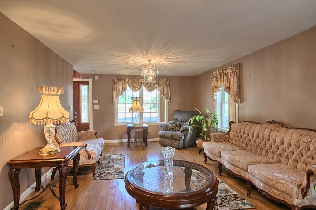 86 Acropolis Road Lowell, MA 01854 - Photo 6 of 30 a living room with furniture a chandelier and a large window