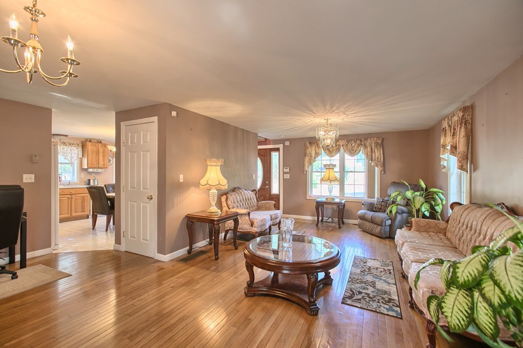 86 Acropolis Road Lowell, MA 01854 - Photo 8 of 30 a living room with furniture dining table wooden floor and a large window