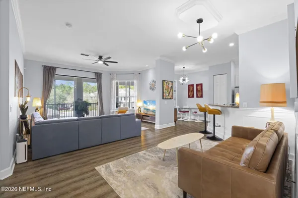 a bedroom with a bed a dresser and a chandelier