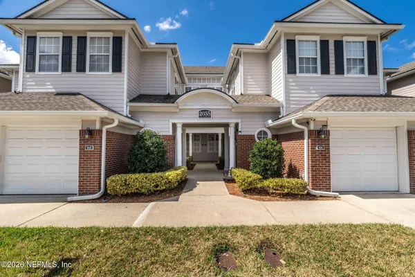 a front view of a house with yard and parking space