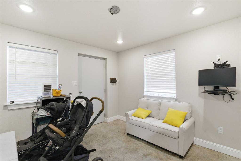 4600 Old Brock Road Weatherford, TX 76087 - Photo 35 of 37 Recessed ceiling lighting illuminates a room featuring two windows with horizontal blinds, a white interior door, and a wall-mounted media console
