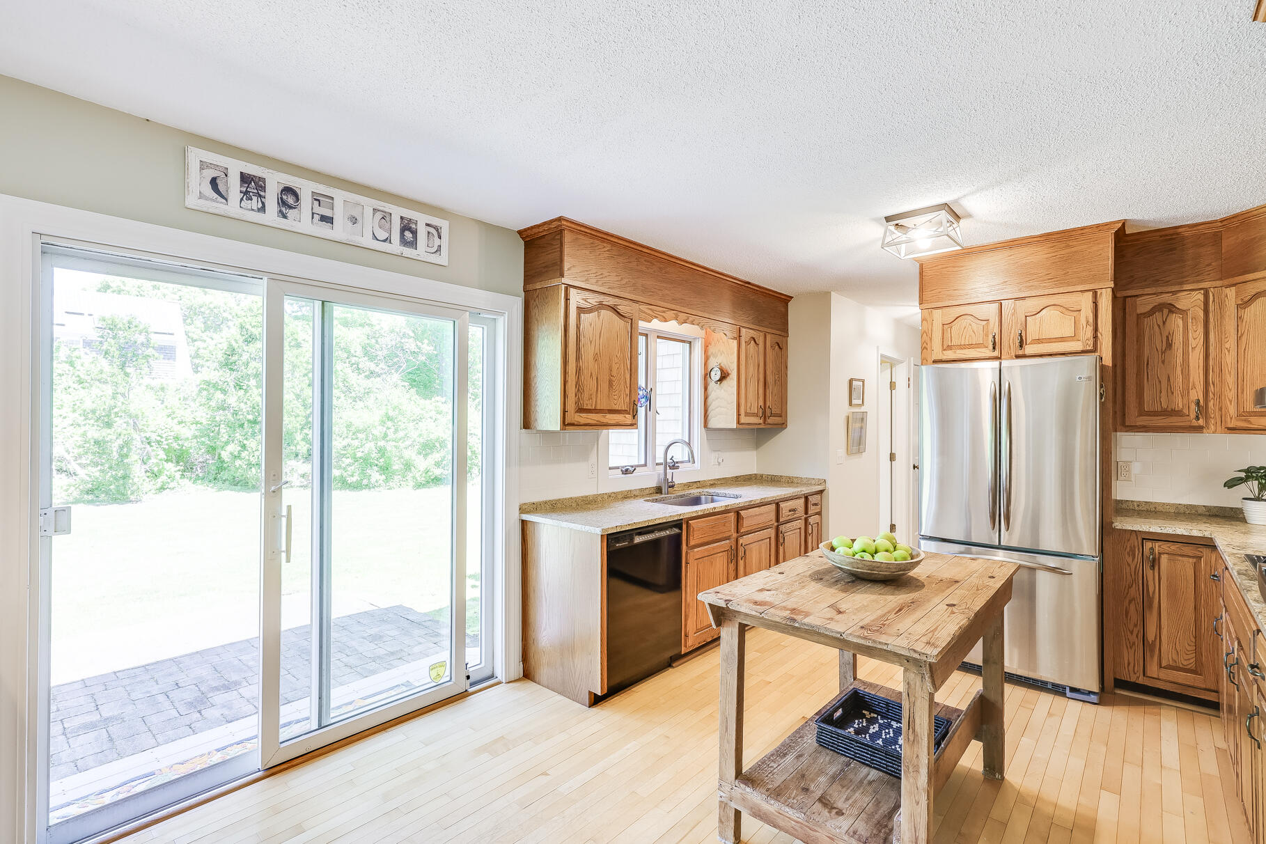 28 Sand Bar Lane Brewster, MA 02631 - Photo 19 of 74 a kitchen with stainless steel appliances granite countertop a stove top oven a sink and a refrigerator