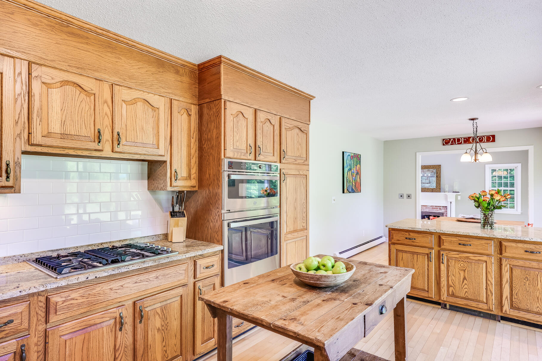 28 Sand Bar Lane Brewster, MA 02631 - Photo 22 of 74 a kitchen with granite countertop a stove a sink dishwasher and wooden cabinets with wooden floor
