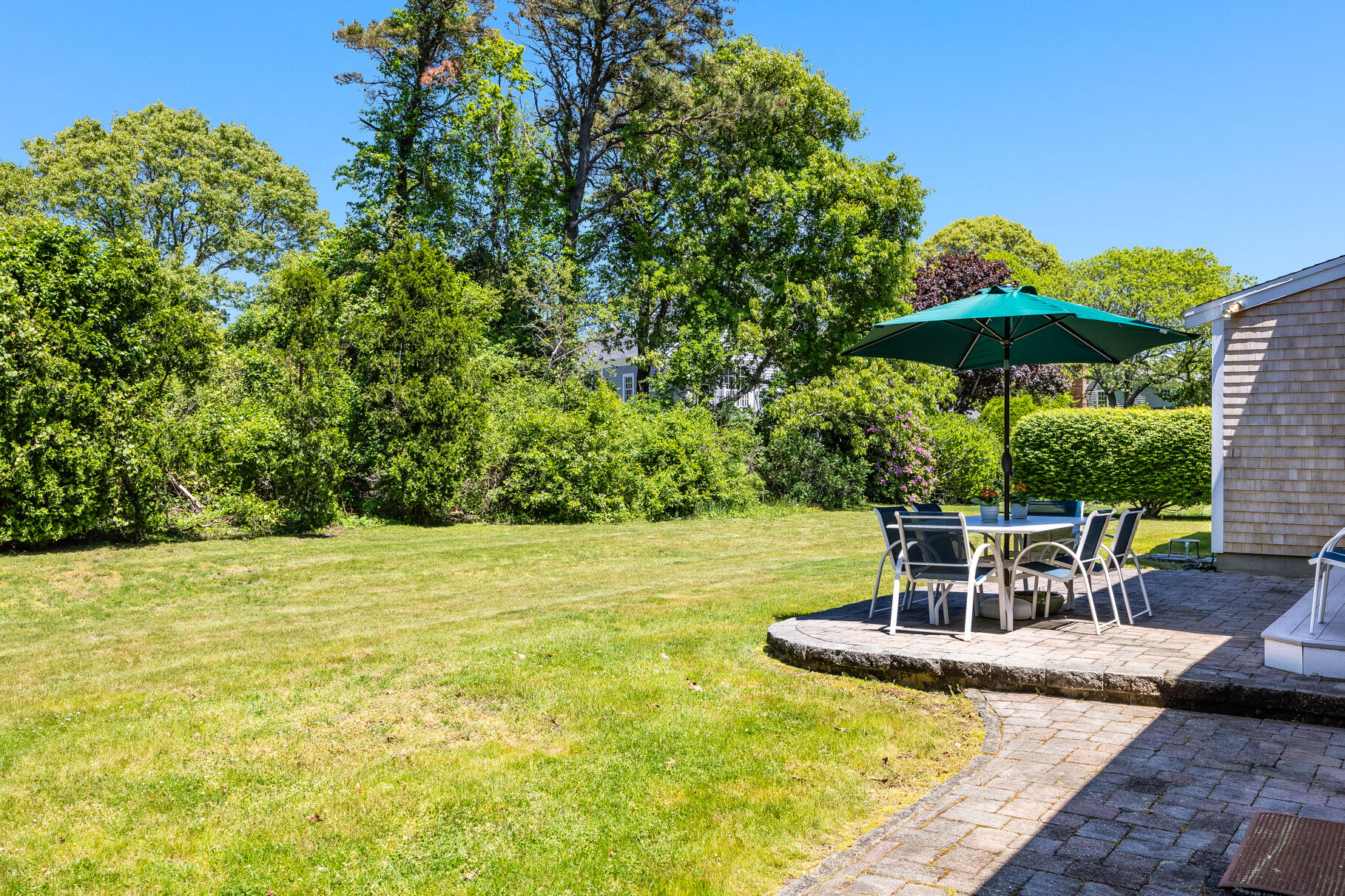 28 Sand Bar Lane Brewster, MA 02631 - Photo 41 of 74 a view of a swimming pool with lawn chairs under an umbrella