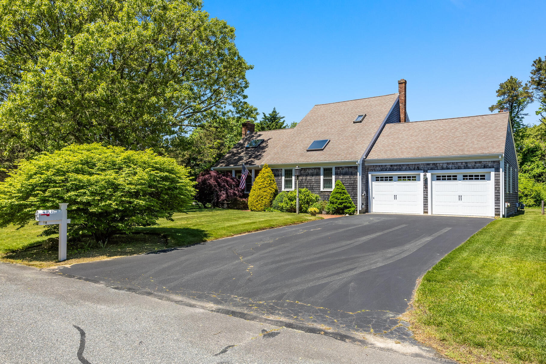 28 Sand Bar Lane Brewster, MA 02631 - Photo 43 of 74 a front view of a house with a yard and garage