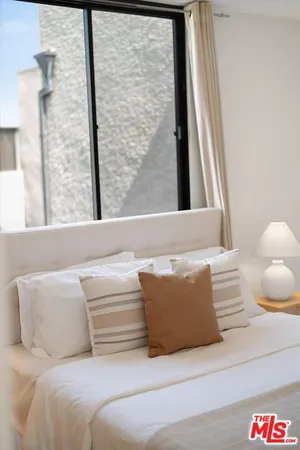 a bedroom with a bed and a potted plant