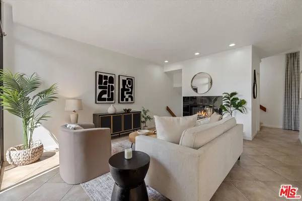 a living room with furniture a fireplace and a potted plant