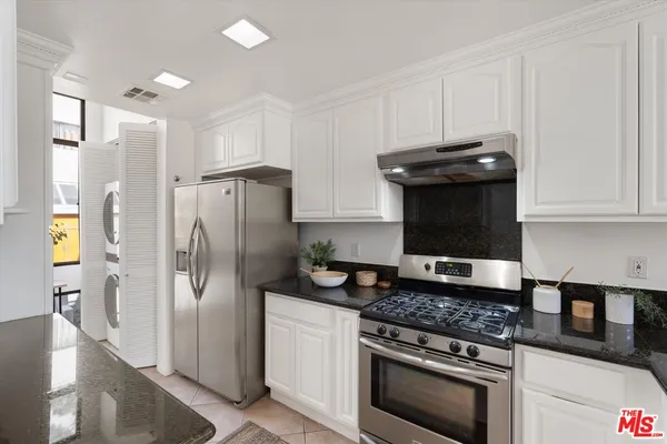 a kitchen with stainless steel appliances granite countertop a refrigerator and a stove
