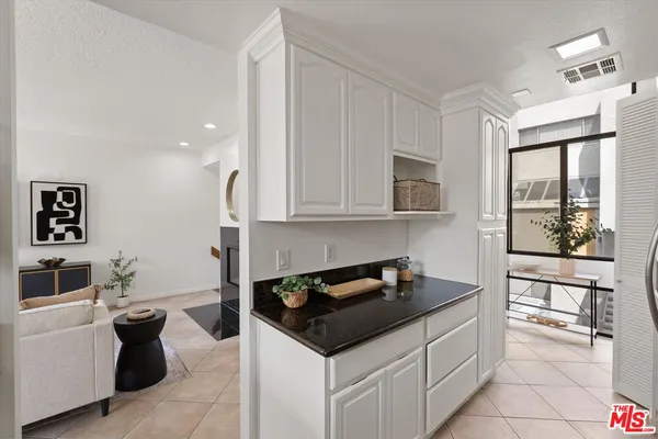 a kitchen with granite countertop a sink stove and cabinets