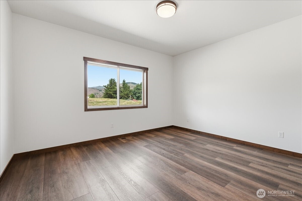 110 Slide View Lane Manson, WA 98831 - Photo 29 of 38 an empty room with wooden floor and window