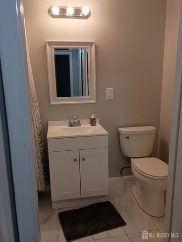 a bathroom with a toilet sink vanity and mirror