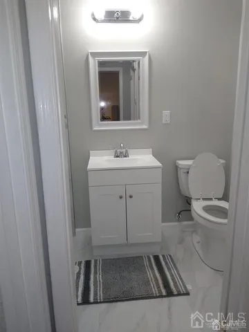 a bathroom with a toilet sink and mirror