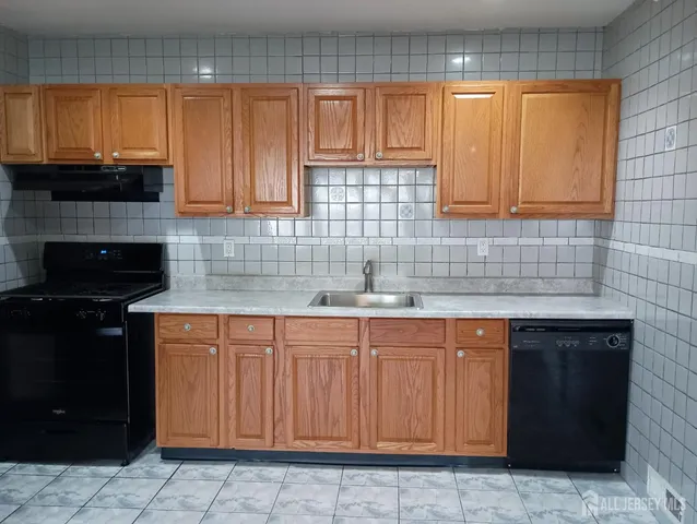 a kitchen with stainless steel appliances granite countertop a stove a sink and a white cabinets