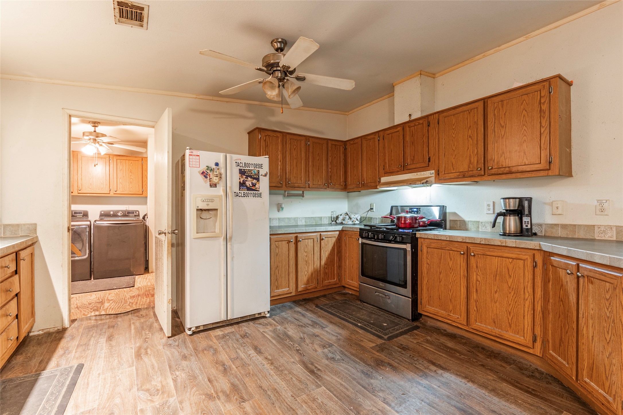 4624 6th Street Bacliff, TX 77518 - Photo 12 of 36 a kitchen with granite countertop a refrigerator oven a sink dishwasher and white cabinets with wooden floor