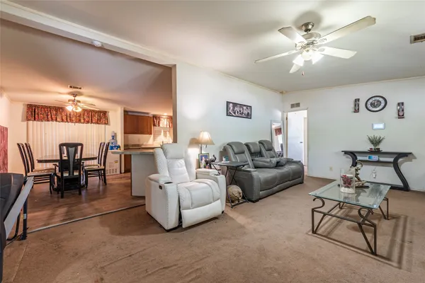 a living room with furniture and view of kitchen