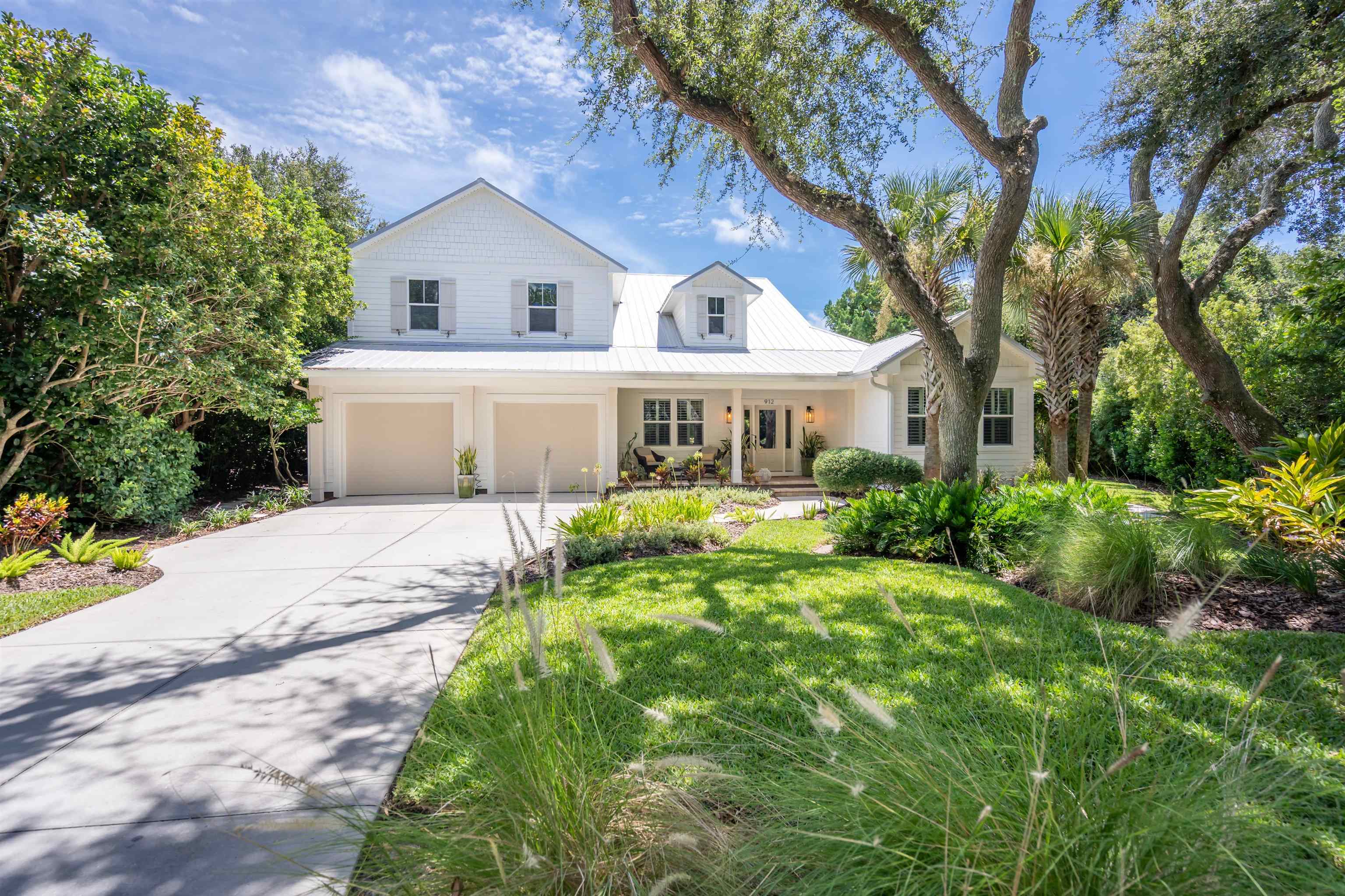 View of front facade with a metal roof, concrete driveway, a garage, and a front yard