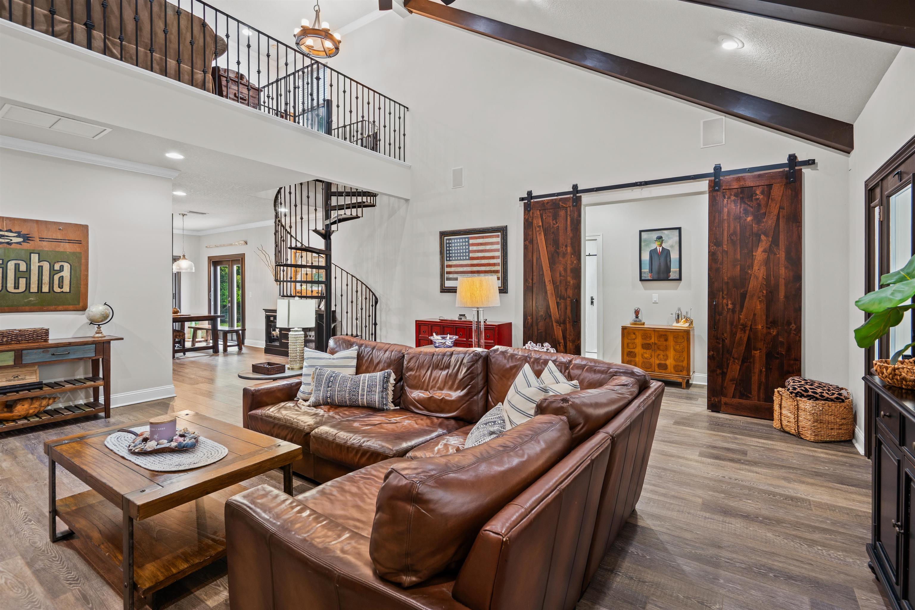 912 Sandy Beach Circle St. Augustine, FL 32080 - Photo 13 of 71 Living room with a barn door, wood finished floors, a towering ceiling, stairs, and recessed lighting