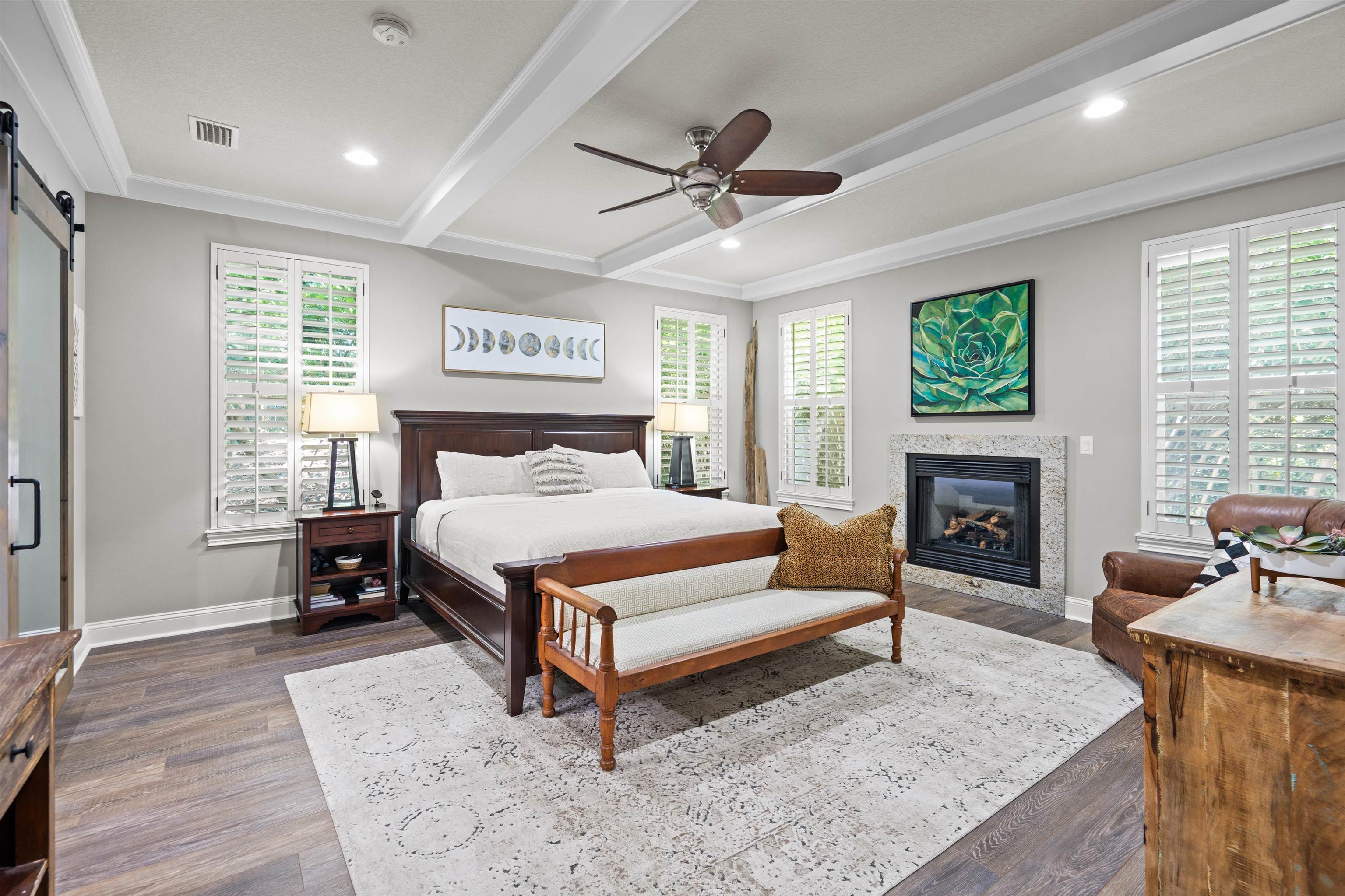 912 Sandy Beach Circle St. Augustine, FL 32080 - Photo 62 of 71 Bedroom with beamed ceiling, a barn door, dark wood finished floors, a glass covered fireplace, and recessed lighting