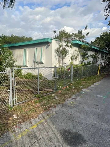 a view of street with flower plants and large trees