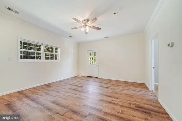a view of empty room with wooden floor