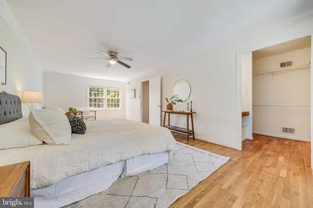 a bathroom with a toilet a sink a mirror a window and vanity