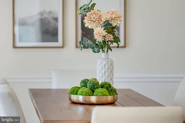 a vase of flowers sitting on a table with a potted plant