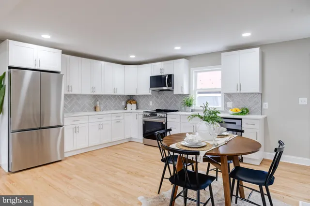 a kitchen with a dining table chairs and refrigerator