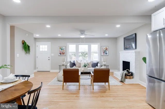 a living room with furniture a fireplace and a dining table with wooden floor