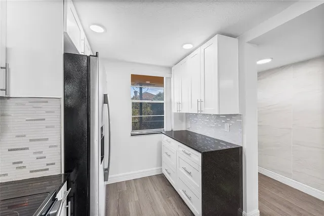 a kitchen with granite countertop cabinets and window