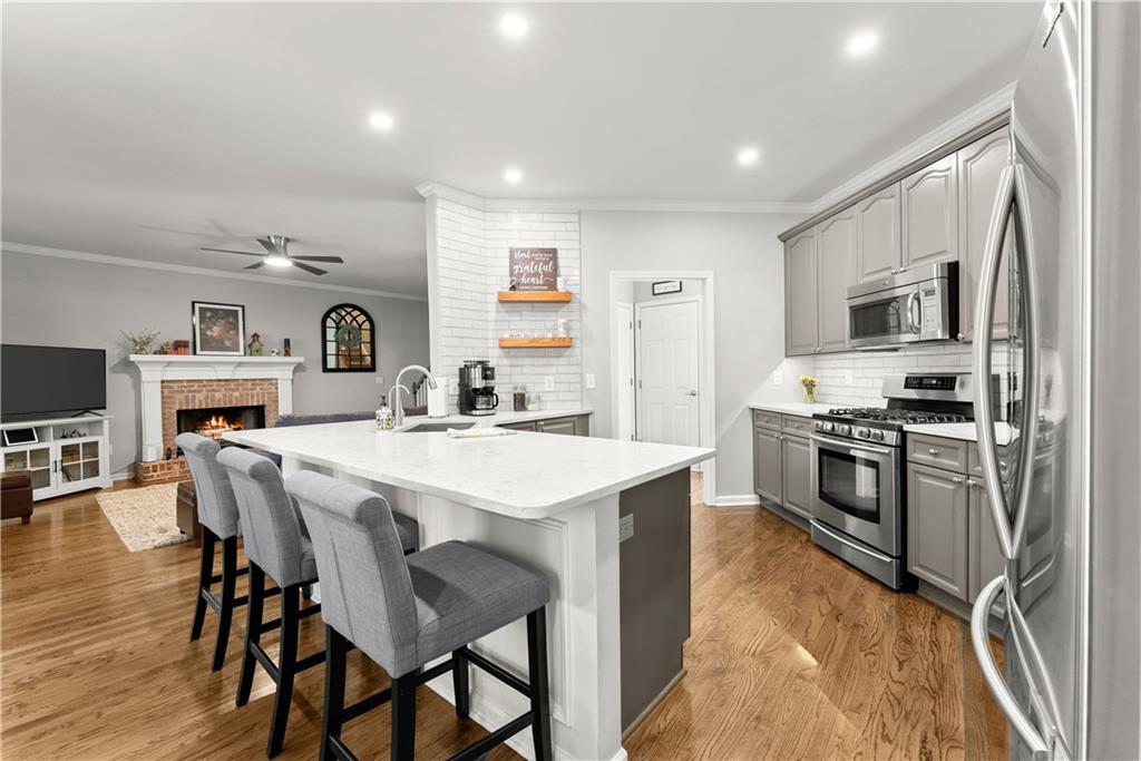 200 Morning Glory Ridge Canton, GA 30115 - Photo 19 of 88 a kitchen with stainless steel appliances kitchen island a table chairs microwave and stove top oven
