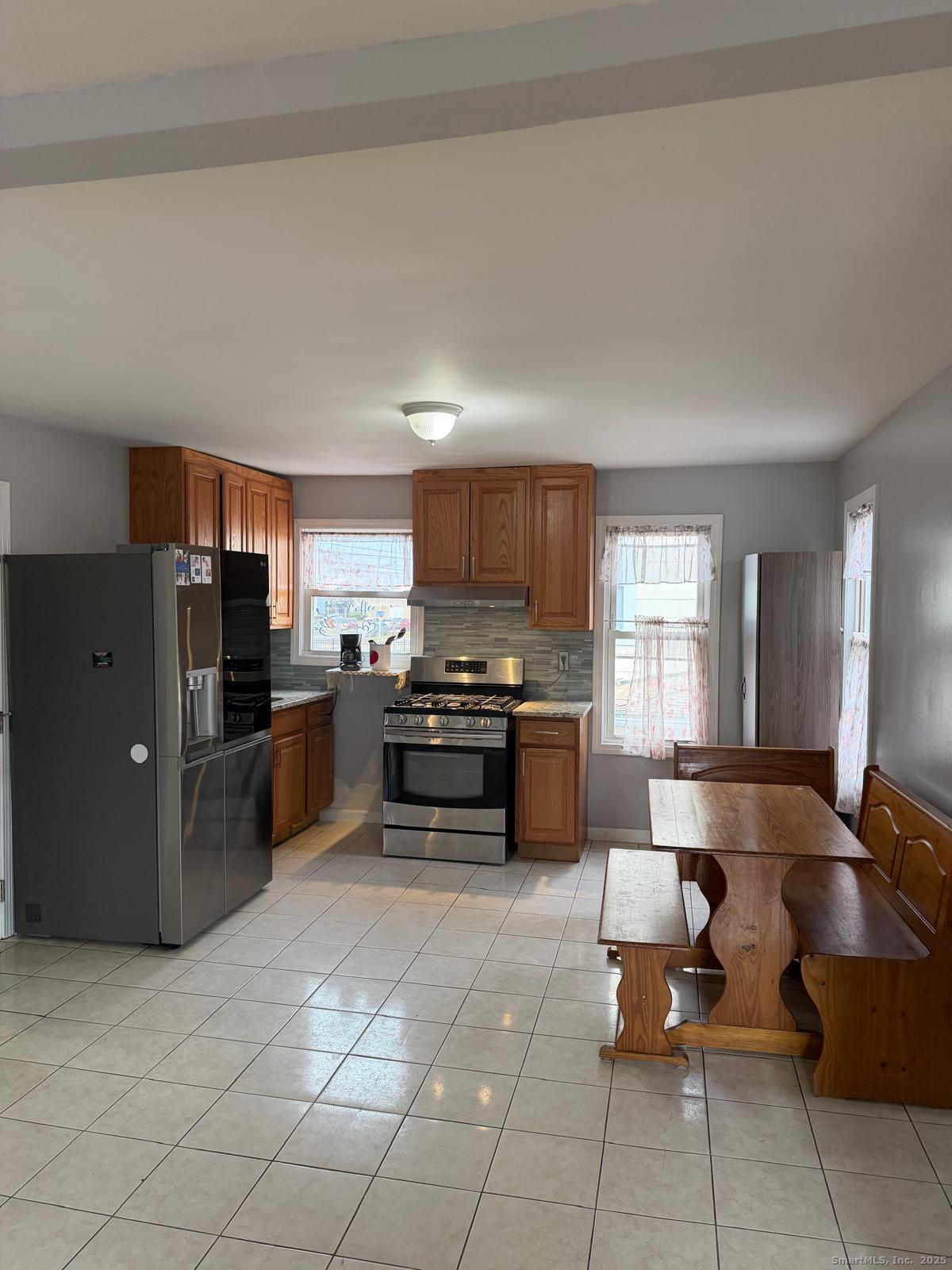 a kitchen with stainless steel appliances a refrigerator and a stove top oven