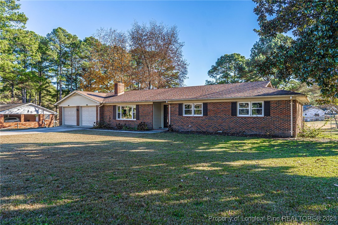 255 Foxcroft Road Whispering Pines, NC 28327 - Photo 2 of 31 a front view of a house with a garden